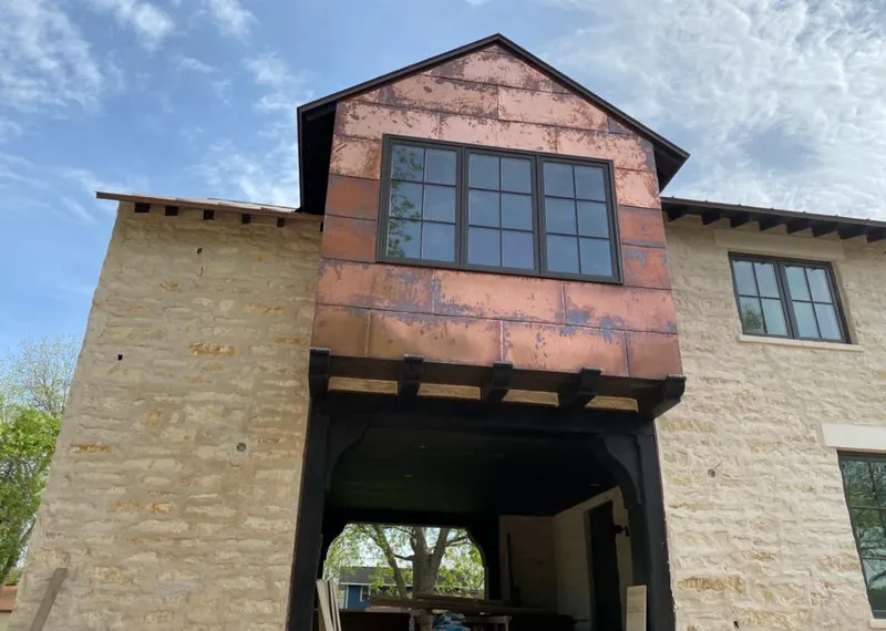 Copper metal panel facade on a stone building for Roof Repair in McGregor